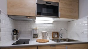 Cafetera o tetera, frigorífico, horno y placa de cocina