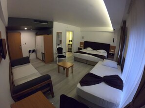 Habitación de hotel con cama, escritorio, silla, armario y baño.