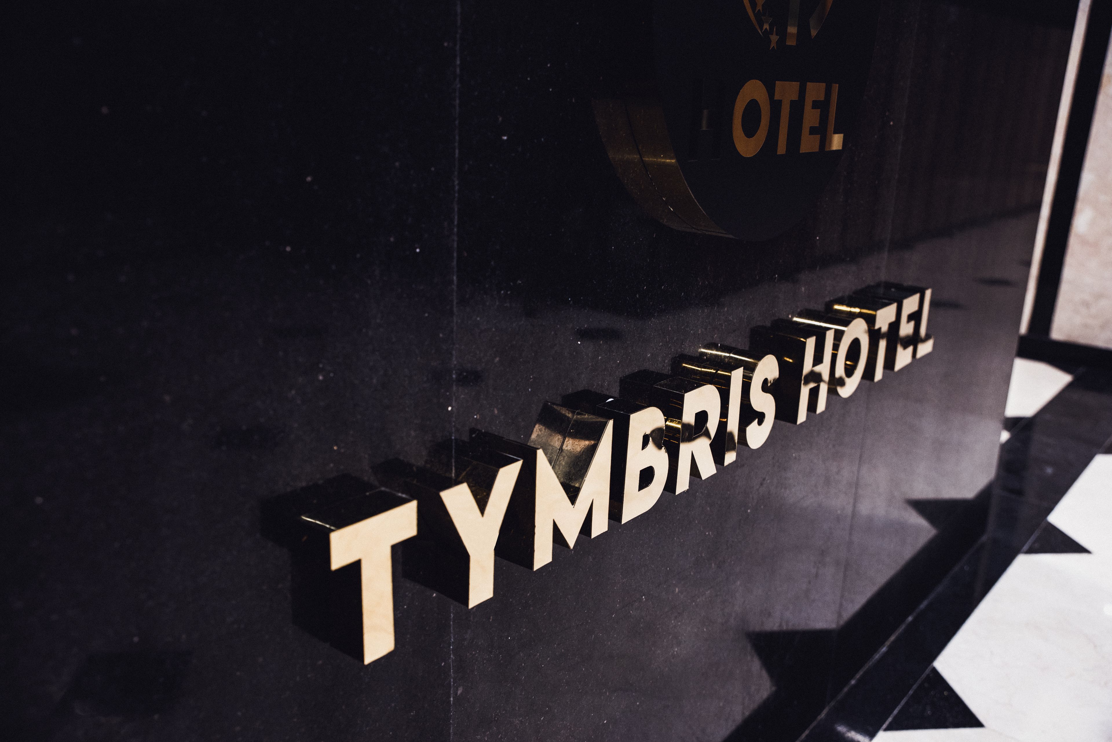 A hotel sign with the name "TYMBRIS HOTEL" in bold, block letters.