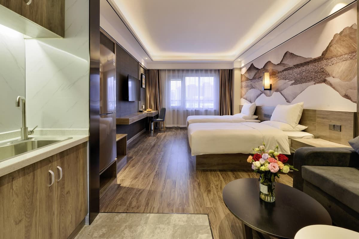 Een moderne hotelkamer met een groot bed, een bureau, een bank en een eettafel.