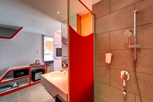 Een moderne badkamer met een douche, een wastafel en een badkamerkast met opbergruimte.