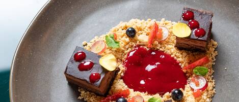 A dessert plate with various toppings and a central red sauce.