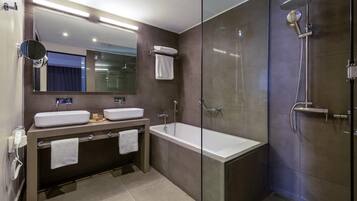 A modern bathroom with a glass-enclosed shower, a double sink vanity, and a large mirror.