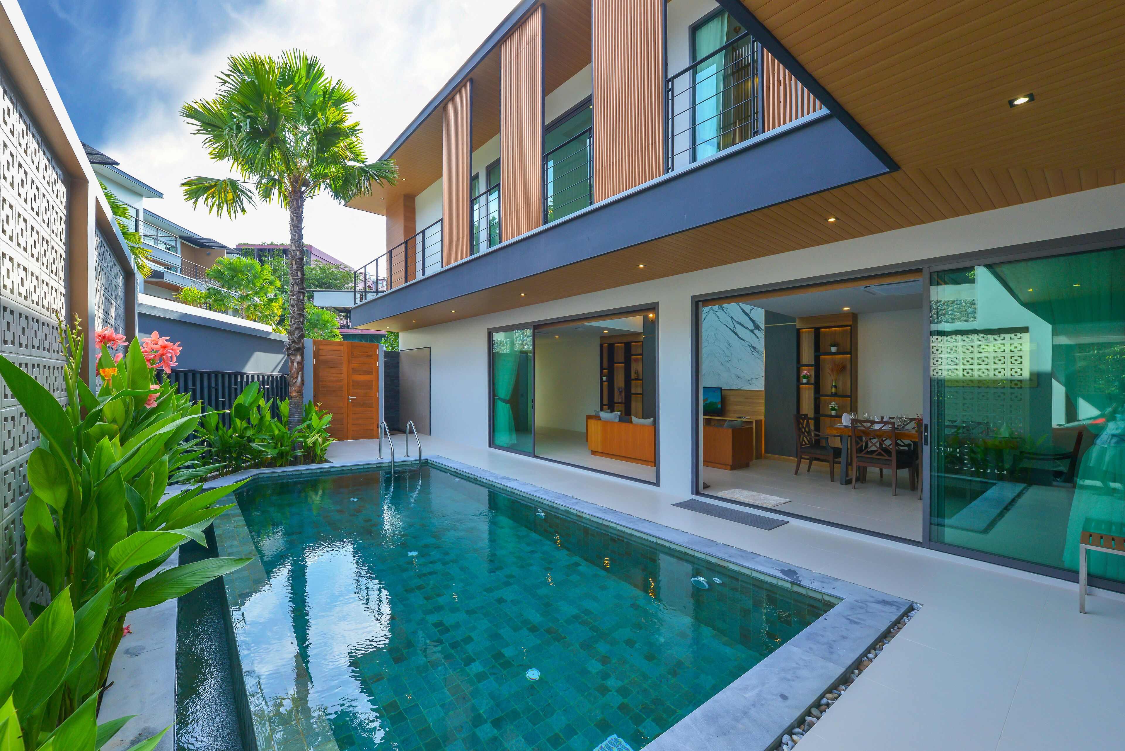 A modern house with a swimming pool, large windows, and a patio area.