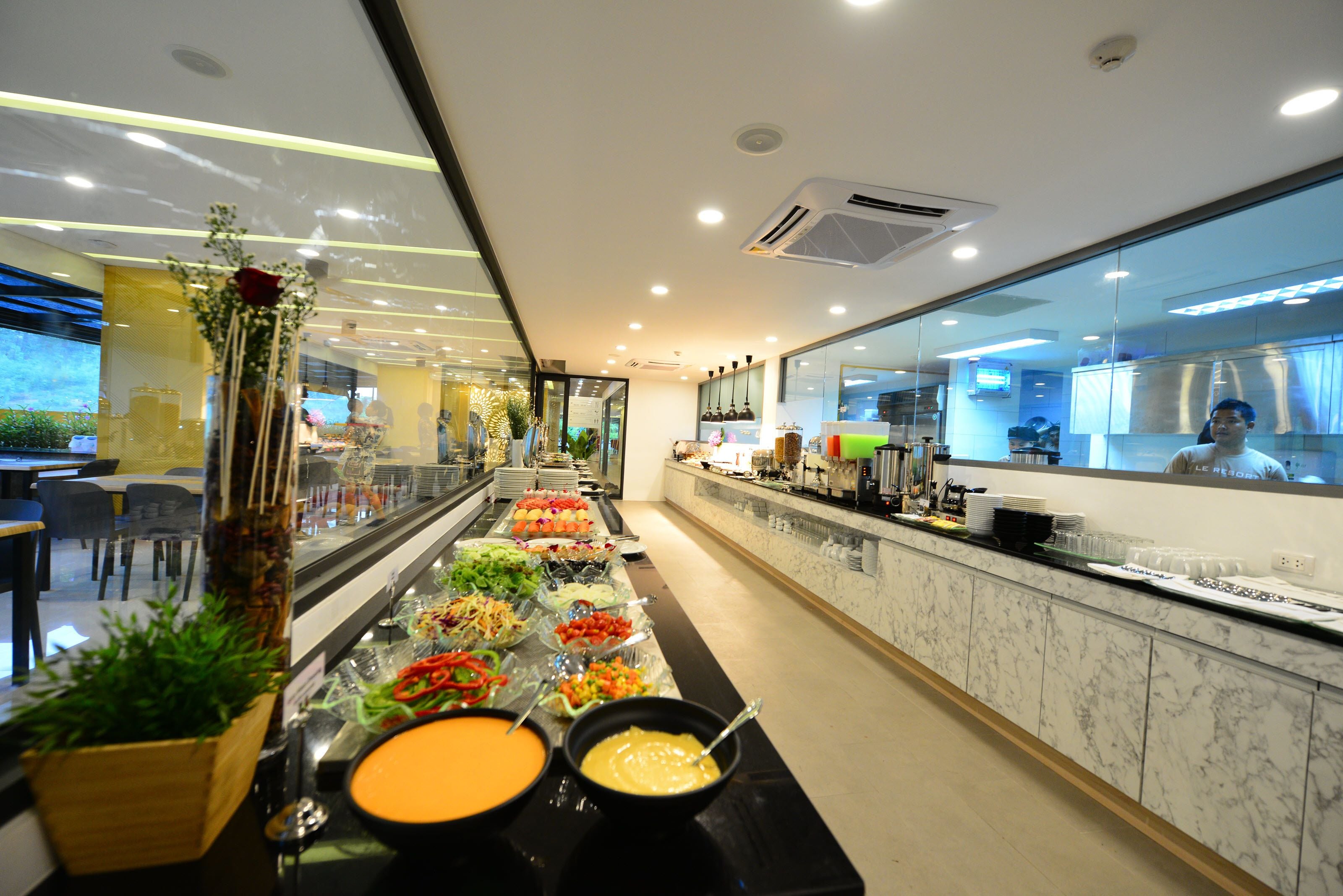 A buffet area with various food options, a marble counter, and a modern kitchen in the background.