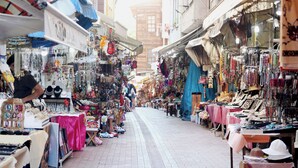 Eine enge Straße mit verschiedenen Geschäften, die Schmuck, Spielzeug und andere Artikel anbieten.