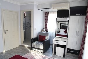 Un dormitorio pequeño con cama, escritorio, silla y armario.