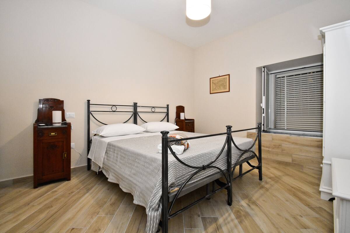Ein Schlafzimmer mit Bett, Nachttisch und Kleiderschrank.