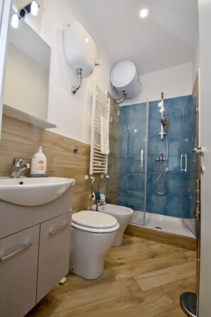 A modern bathroom with a sink, toilet, and shower. - Il Timone Bed and Breakfast (Castellammare di Stabia)