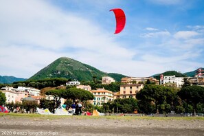 A coastal town with buildings, a hill, and a red kite in the sky. - Il Timone Bed and Breakfast (Castellammare di Stabia)