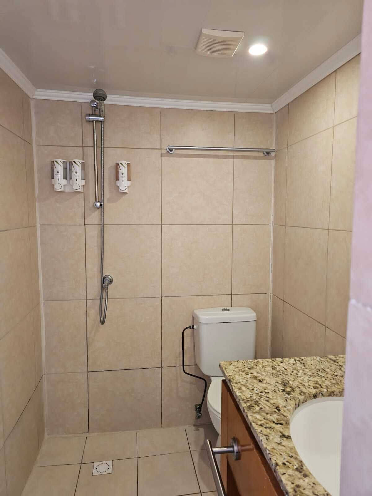 Un bagno con doccia, WC e lavandino.