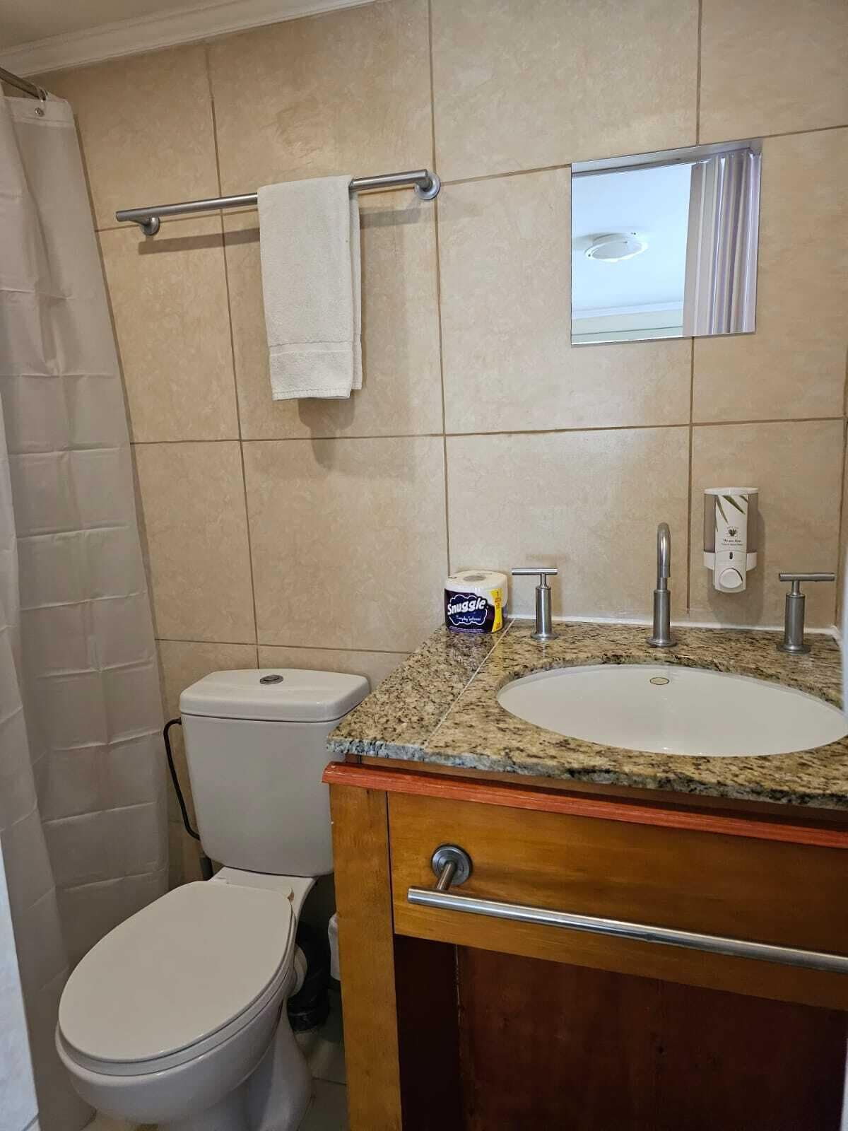 Une salle de bain équipée de toilettes, d’un lavabo et d’un porte-serviettes.