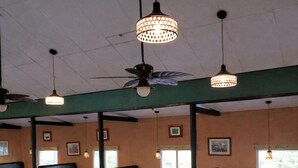 A restaurant with booths, tables, ceiling fans, and pendant lighting. - Honduyate (Santa Cruz de Yojoa)