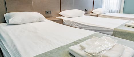 Deluxe driepersoonskamer | Luxe beddengoed, pillowtop-bedden, een laptopwerkplek