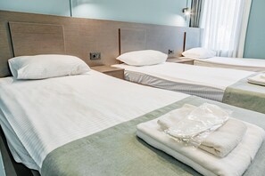 Deluxe driepersoonskamer | Luxe beddengoed, pillowtop-bedden, een laptopwerkplek