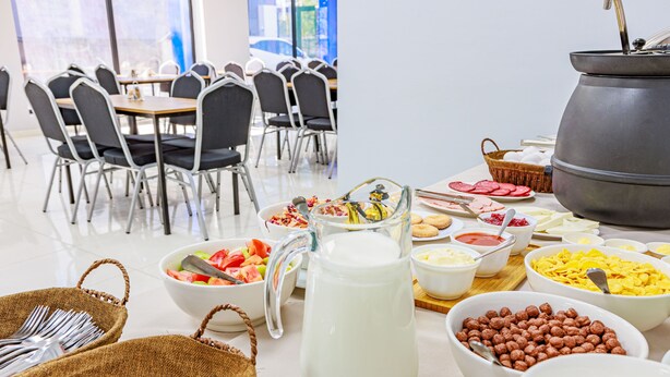 A buffet setup with various food items and utensils. - Route Hotel (Tbilisi)