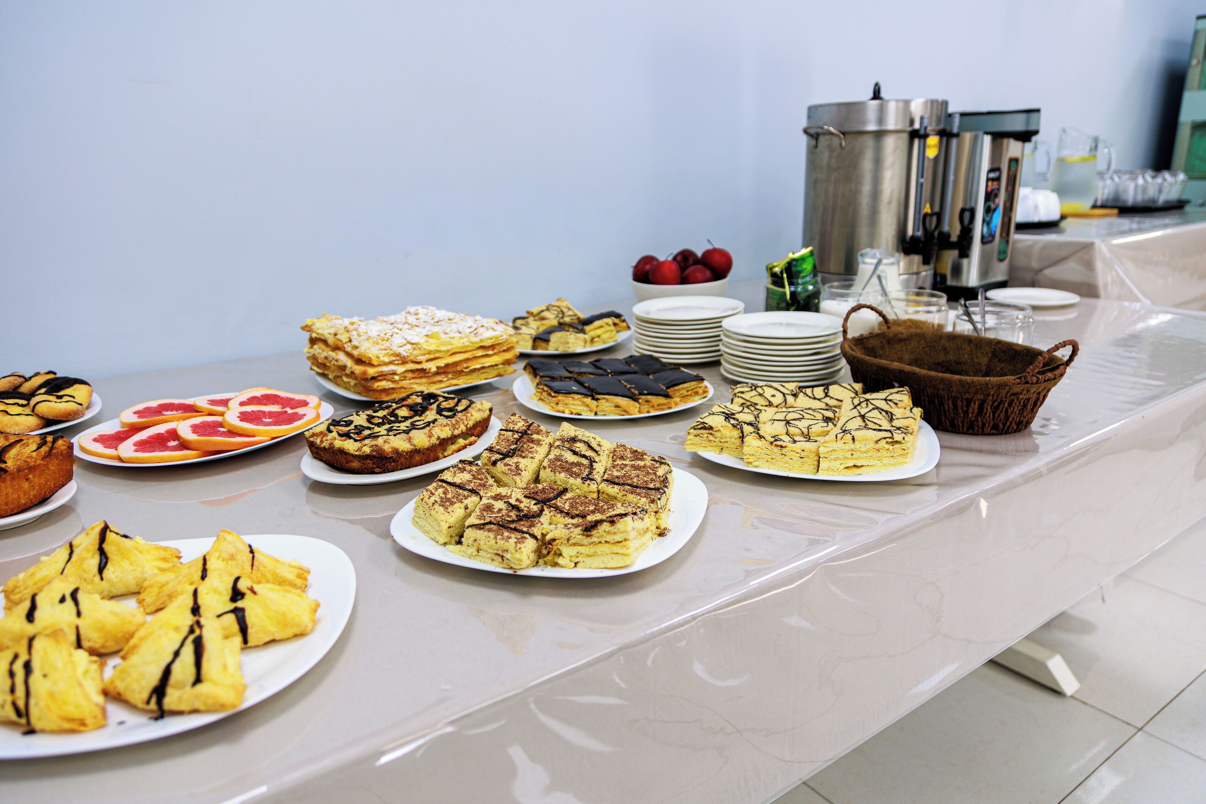 A buffet table with various desserts and fruits.