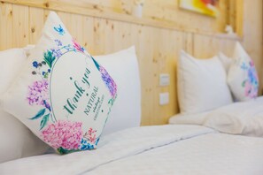A bed with white bedding and a pillow with a floral design and the text "Thank you Natural Vintage Greeting Card". - myhappiness-hotel (Hualien City)