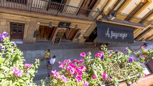 A building with a black awning labeled "A la vida vieja." - Pensión Amaiur (San Sebastián)