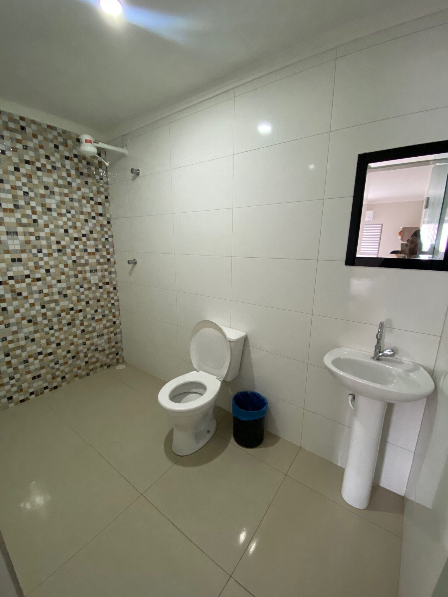 Un baño con inodoro, lavabo y paredes de azulejos.
