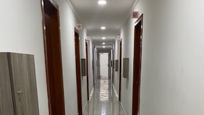 A long, narrow hallway with doors numbered 06 to 10, leading to individual rooms. - Hotel Cumbica (Guarulhos)