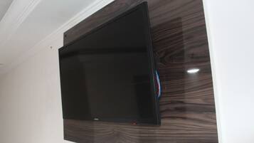 Un televisor de pantalla plana montado en una pared con textura similar a la madera.