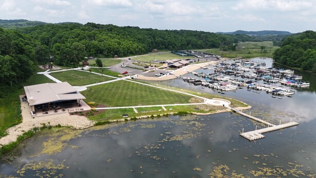An aerial view of a lakeside property with a marina, a large building with a patio, and surrounding greenery. - Beautiful home near resort amenities, WIFI (Galena)