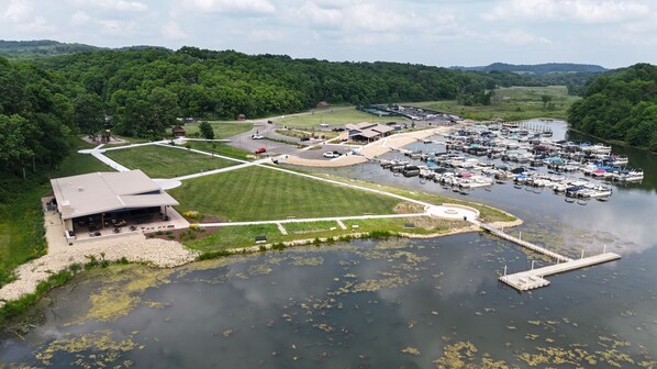 An aerial view of a lakeside property with a marina, a large building with a patio, and surrounding greenery. - Beautiful home near resort amenities, WIFI (Galena)