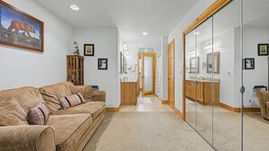 Una sala de estar con un sofá, un armario de madera y un cuadro en la pared.