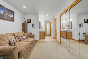 A living room with a sofa, a wooden cabinet, and a painting on the wall. - Beautiful home near resort amenities, WIFI (Galena)