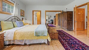 Un dormitorio con cama, armario de madera y un espejo grande.