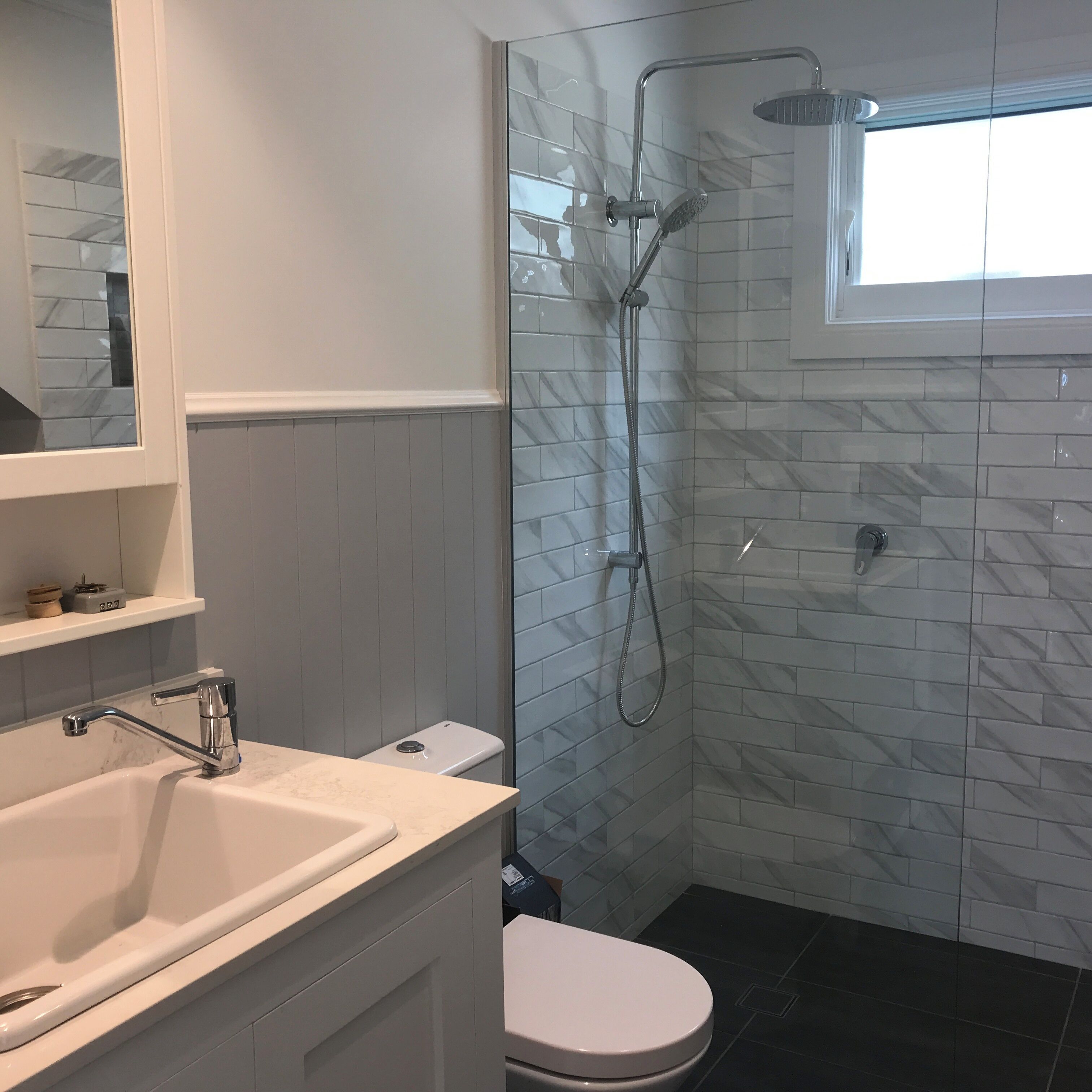 A bathroom with a shower, toilet, and sink.