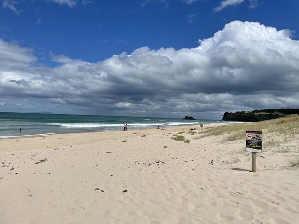Een strand met een waarschuwingsbord voor gevaarlijke stromingen.