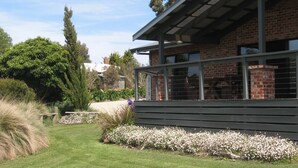 A modern house with a brick exterior, large windows, and a covered porch. -  Prom Coast Holiday Lodge (Waratah North)