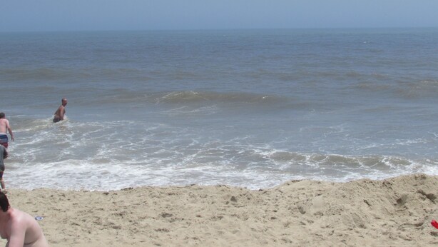 En strand med en sandstrand och havet.