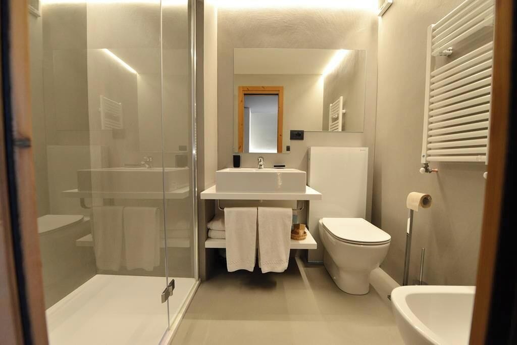 A modern bathroom with a glass shower enclosure, a white sink, a toilet, and a bathtub.