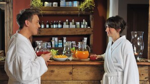 A wooden counter with a variety of beverages and snacks, a shelf with jars and containers, and a rustic interior. - La Madonnina del Gran Paradiso (Cogne)