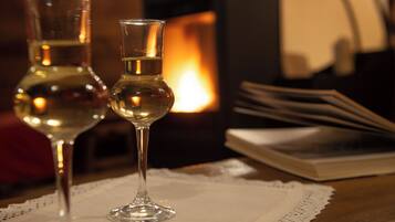 Deux verres à vin sont posés sur une table devant une cheminée allumée.