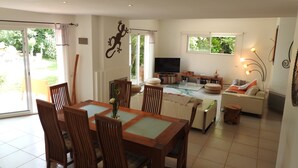 A spacious living room with a dining area, large windows, and a television. - Upscale villa near UZES, private swimming pool, enclosed grounds, Wifi. (Collias)