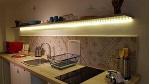 A kitchen with a wooden countertop, a sink, a dish rack, a toaster, and a kettle. - Brau&Frau <br>apartment in Taranto (Taranto)