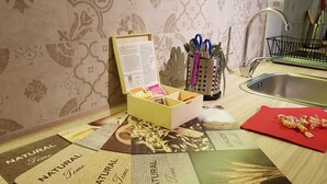 A kitchen counter with a cutting board, a box of utensils, and a red cloth. - Brau&Frau <br>apartment in Taranto (Taranto)