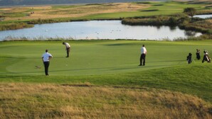 A golf course with a pond, open grassy areas, and a few golfers. - 5* Self Catering Penthouse, Llanelli, Beach, Sea Views, Walks, Golf, Cycle. (Llanelli)