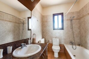 Bañera, secador de pelo, toallas y jabón