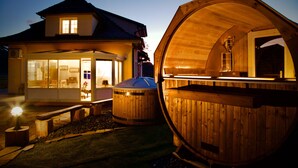 Een houten hutje met een groot raam en een bankje buiten.