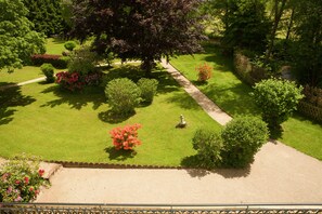 Un jardin bien entretenu, agrémenté de diverses espèces d’arbustes et doté d’un chemin central.
