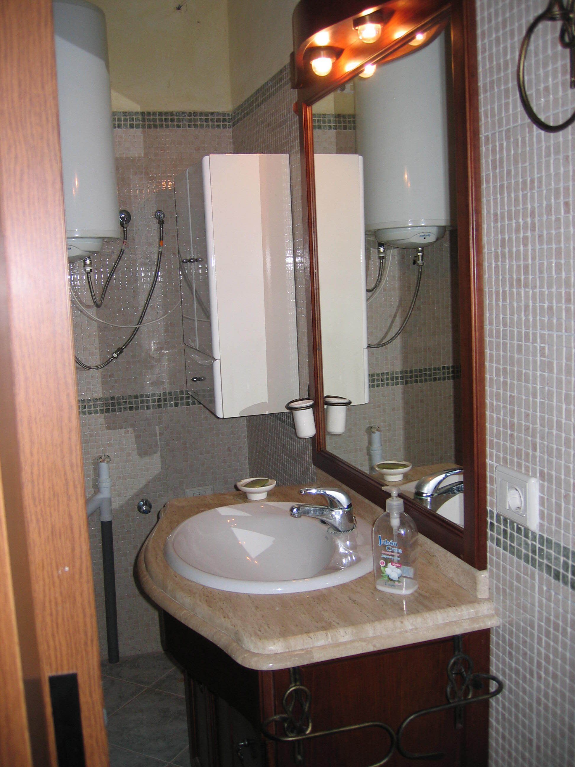 A bathroom with a sink, mirror, and towel rack.