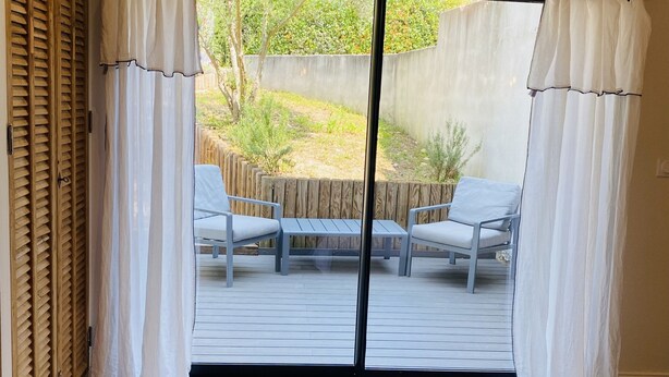 A room with a sliding glass door leading to an outdoor patio with two chairs and a table. - Villa 220m2, land 3000m2, 5 "village on foot, 4km Saint-Rémy-de-Provence (Eyragues)