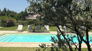 A swimming pool with lounge chairs, surrounded by grass and trees. - Villa 220m2, land 3000m2, 5 "village on foot, 4km Saint-Rémy-de-Provence (Eyragues)