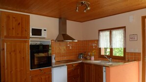 A kitchen with wooden cabinets, a microwave, a stove, and a sink.