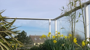 A conservatory with yellow daffodils and bamboo plants. - quiet comfort cottage, sea view, terraces and heated indoor pool (Ver-Sur-Mer)